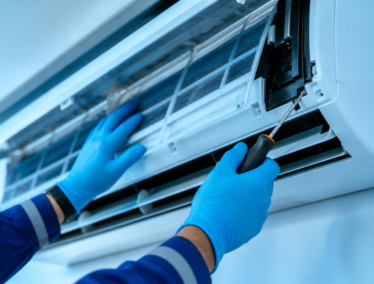 Technician servicing the internal components of an air conditioning unit